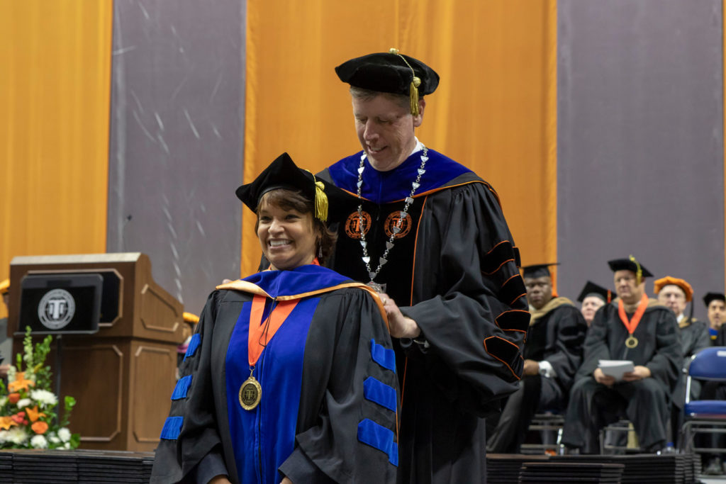 A Ph.D. graduate being given her hood by President Einolf during the 2019 Commencement ceremony