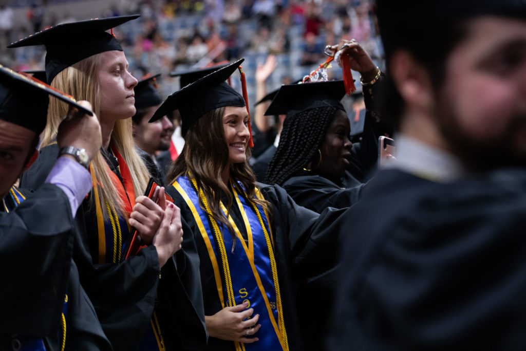 Graduating students moving their tassels on their caps as the new graduates of 2019
