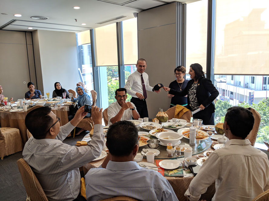 Sharmila Chowdhury, Director of International Admissions, presenting a graduate alumni with a Indiana Tech Warriors I TECH baseball hat in Malaysia during a special alumni luncheon.