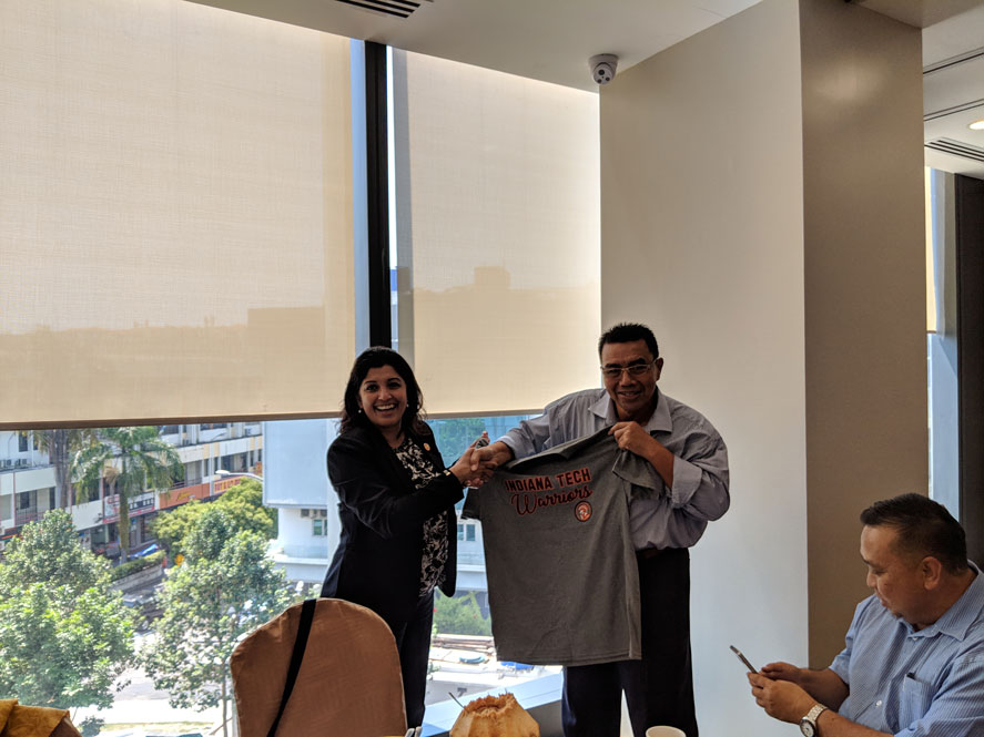 Sharmila Chowdhury, Director of International Admissions, presenting a graduate alumni with a Indiana Tech Warriors T-shirt in Malaysia during a special alumni luncheon.