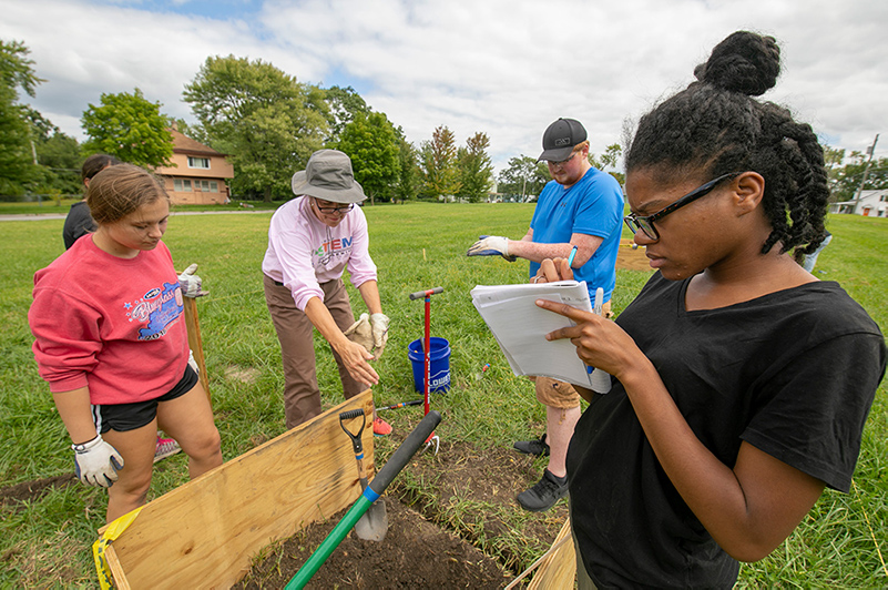 Dr. Julie Davis Good assisting students with an earthworm survey project