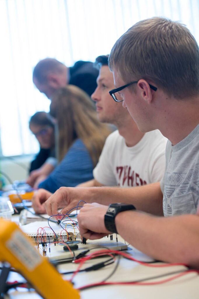 Dr. David Rumsey assisting students in his Electrical Engineering class