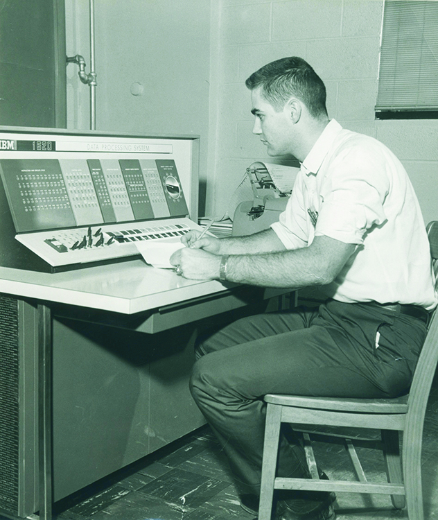 a photo of a student working at the IBM 1620 computer during the 1960s at Indiana Tech.