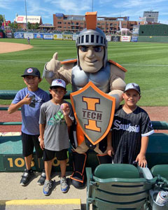 Maximus posing with kids at a South Bend Cubs game